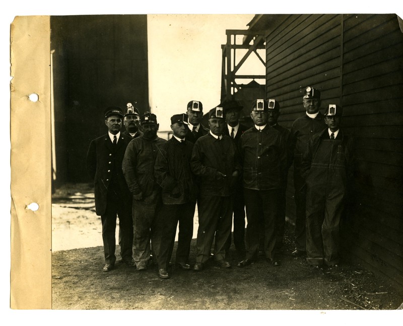 Group of men standing outside at the coal mines