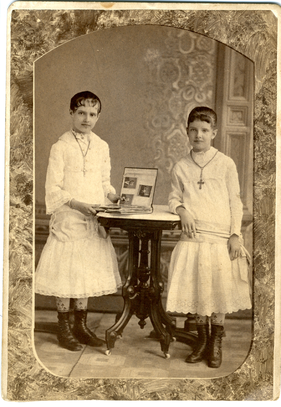 Photograph of two girls looking through a photo album in 1879