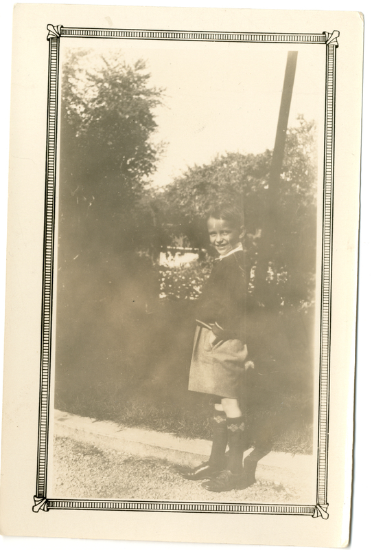 Photograph of a young boy posing outside.