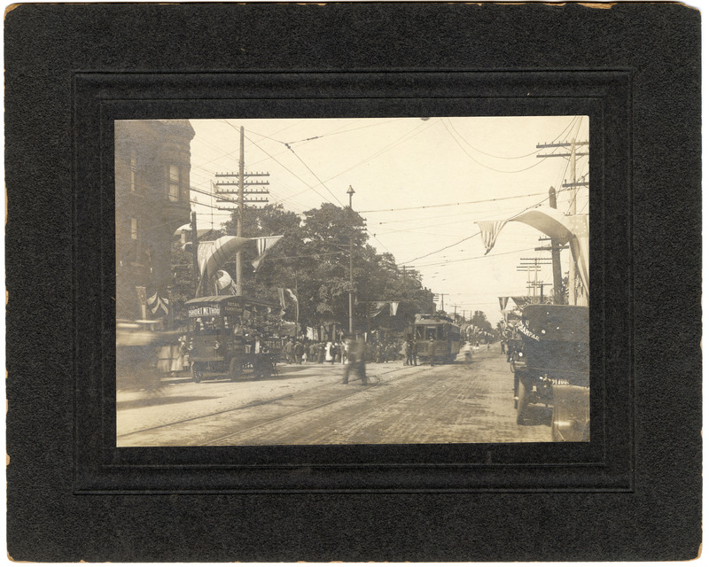 1912 Photograph of a Street Scene with Trucks and a Trolley During the Madison County Centennial Celebration
