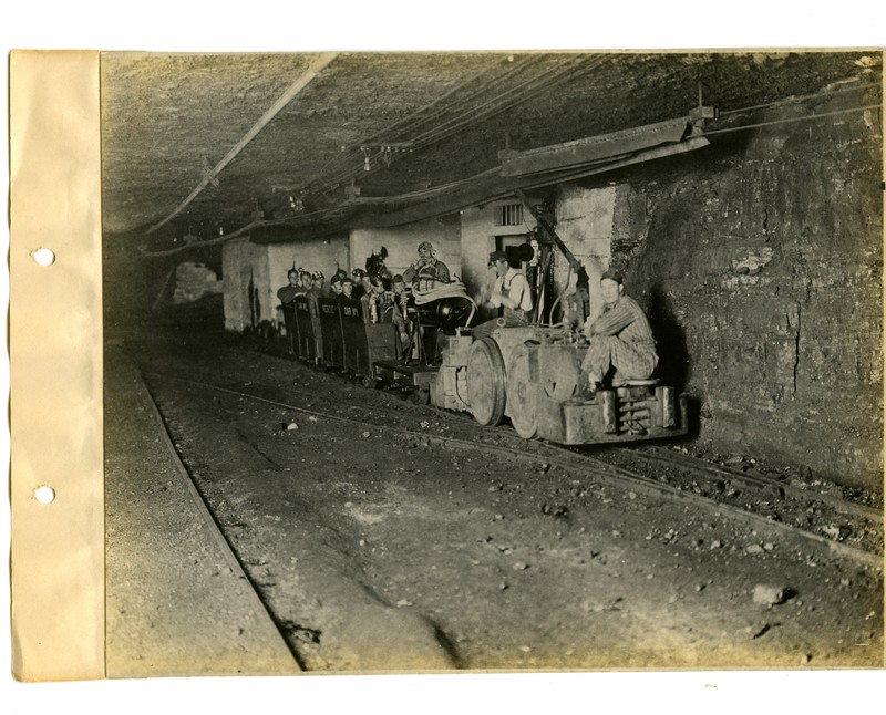 Shift workers riding on rail carts in the mines 
