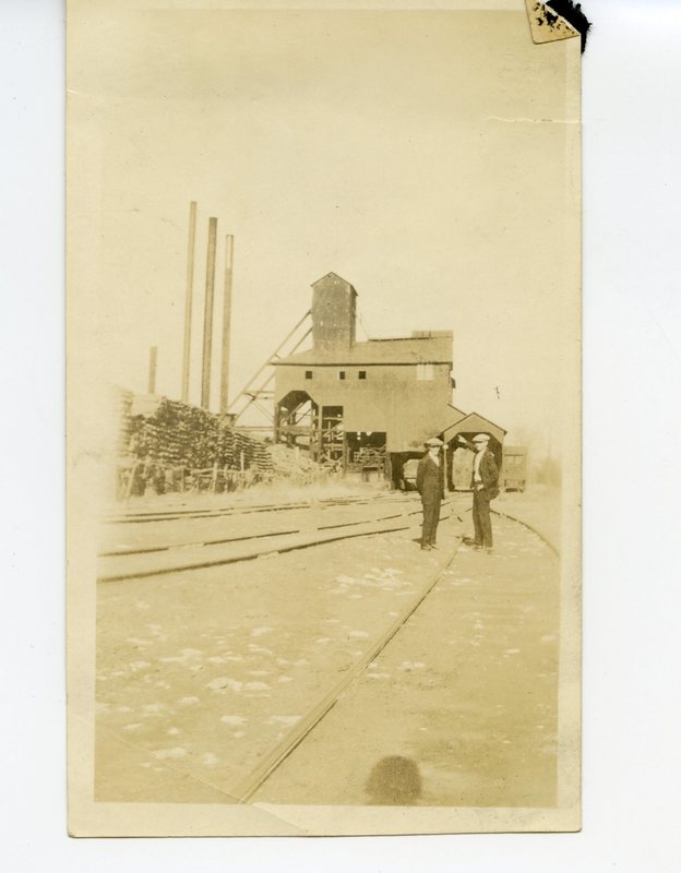 Young men standing outside of coal mine #2 by lumber stacks in Glen Carbon, Illinois.