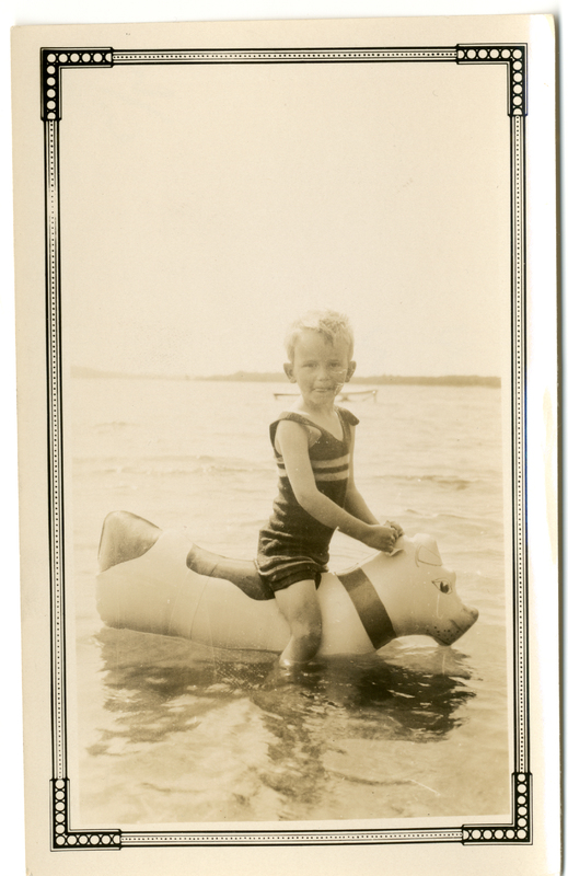 Photograph of a young boy on a floatie in a lake