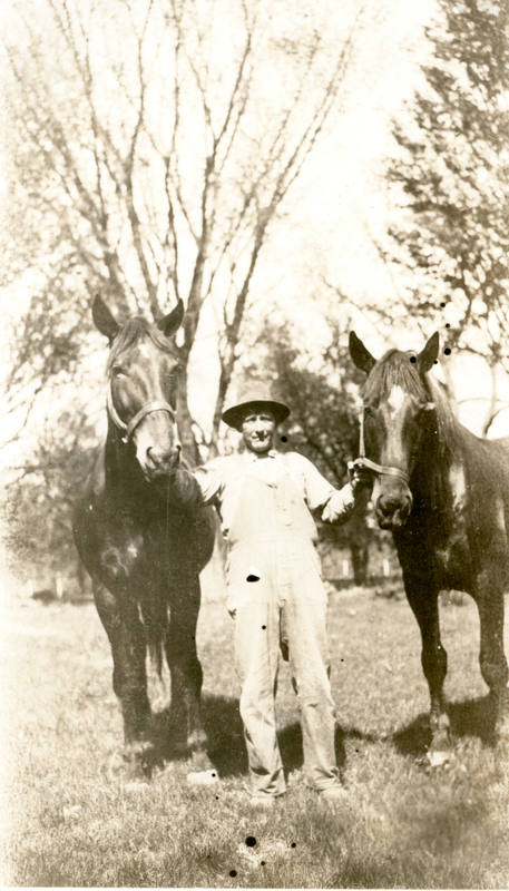 Photograph of Charlie Glassmaker with two horses on the Mudge farm in Grantfork