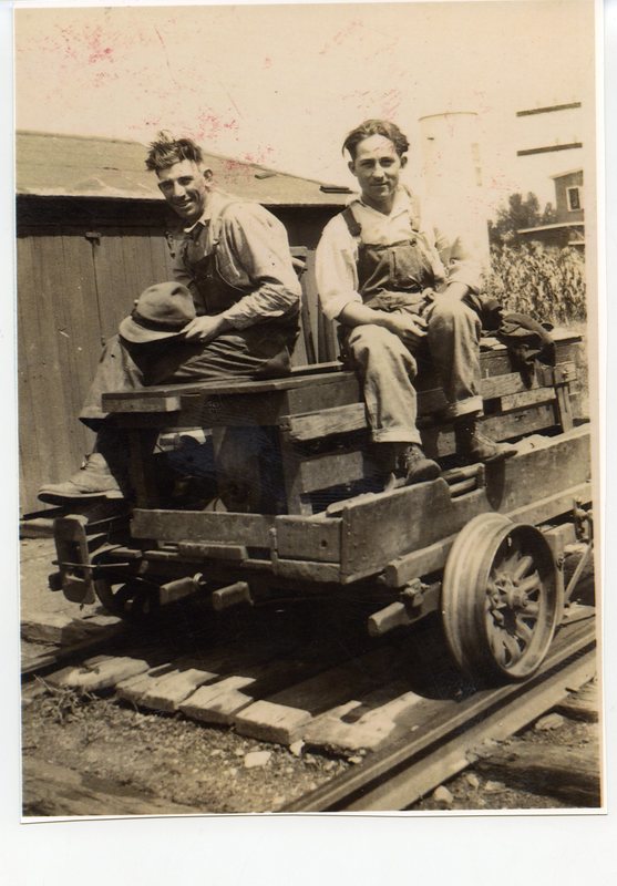 Two Railroad Workers Sitting on Cart