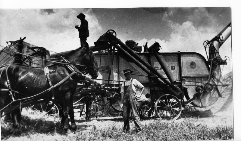 Man and Young Boy in Front of Helfer’s Threshing Machinery