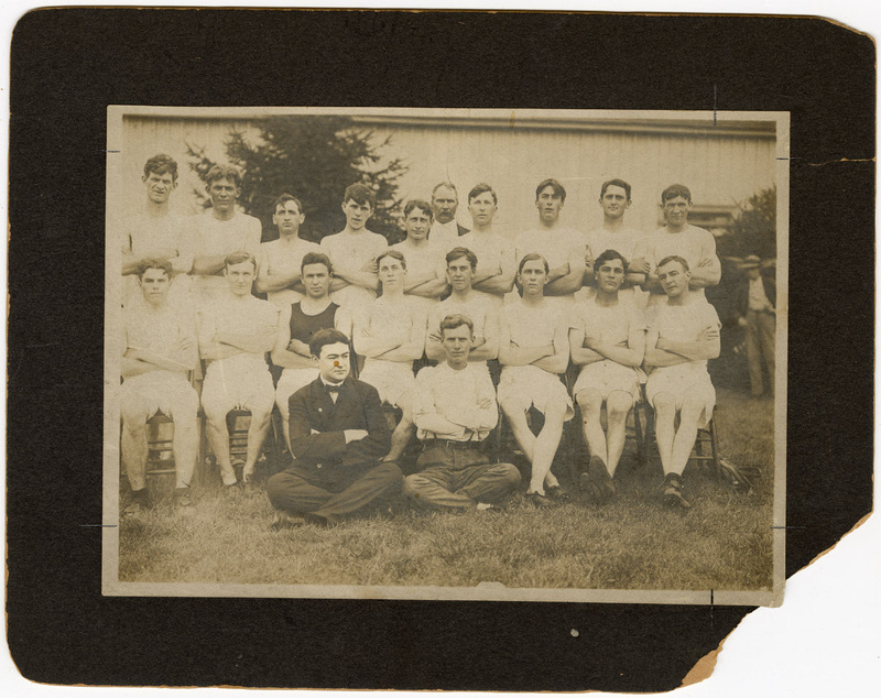 Photograph of Three Rows of Men in White Athletic Uniforms Sitting with Arms Crossed