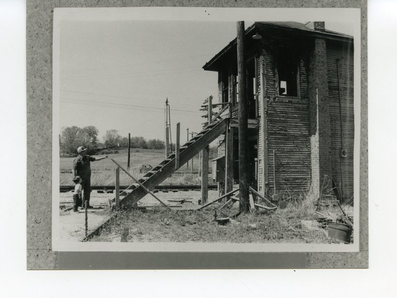 Man and young boy visit old railroad tower   