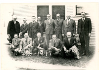 1947 Thirteen Men Posing for Group Photograph in Front of Building 