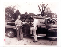 1948 Two men standing outside of Car