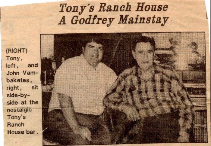 A yellowed newspaper clipping showing two men sitting down.